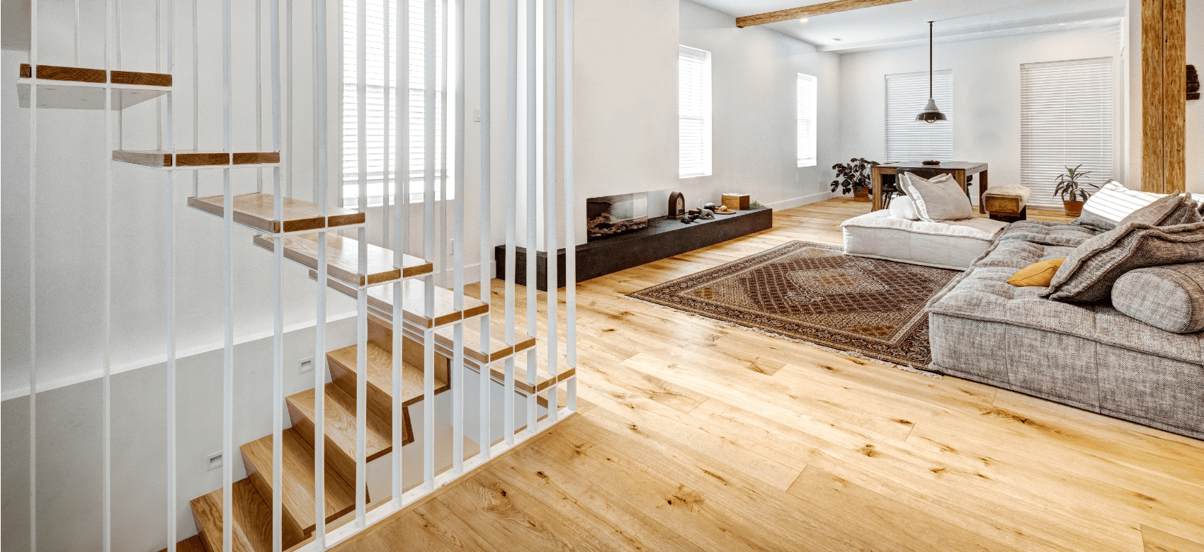Wohnzimmer mit Parkettboden und moderner Einrichtung und Treppenhaus mit Holzstufen